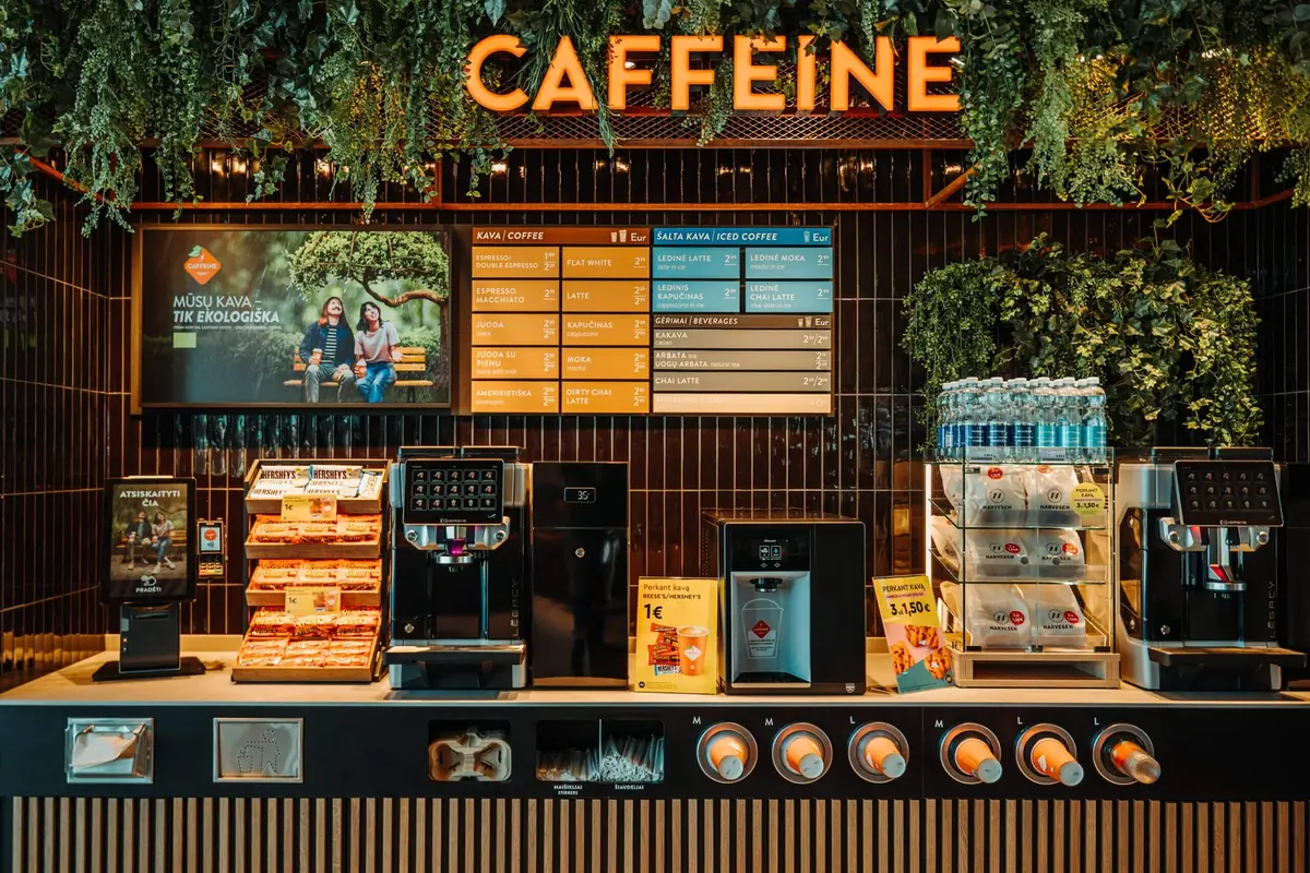 A Caffeine coffee shop counter with digital menu screens