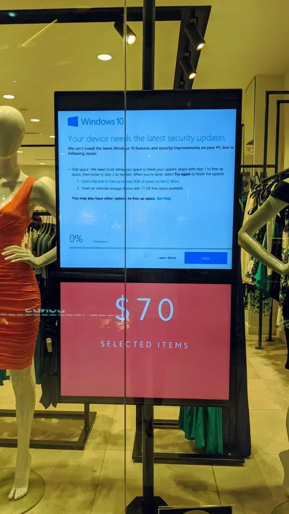 Digital signage screen showing a Windows 10 update interruption message, highlighting the problem solved by impressBox's Linux-based solution